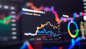 Auf einem digitalen Bildschirm werden verschiedene Finanzdiagramme und -tabellen angezeigt, wobei reale Vermögenswerte nahtlos mit bunten Linien und dynamischen Datenvisualisierungselementen integriert werden.