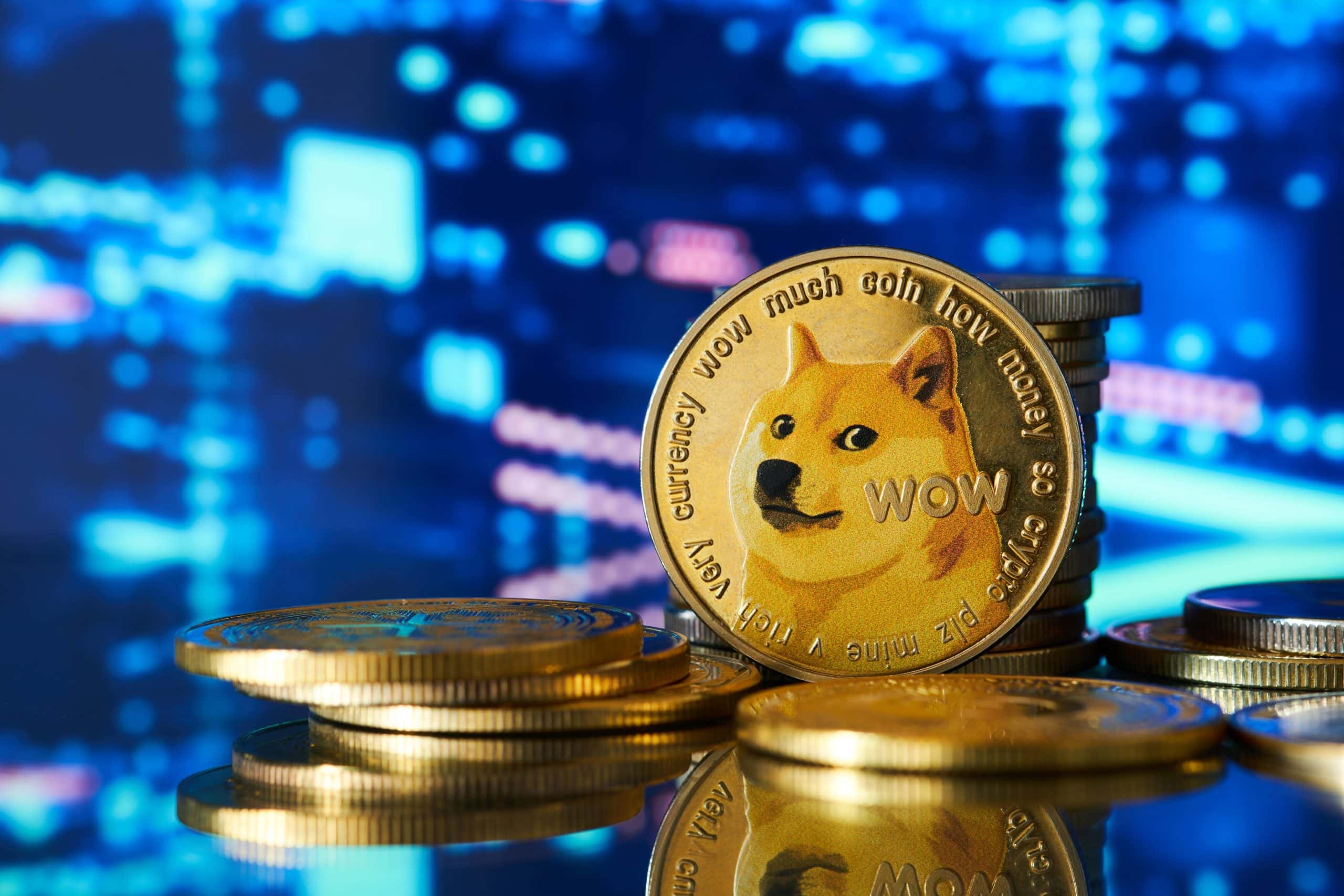 Ein Stapel physischer Münzen mit dem Gesicht eines Shiba Inu und dem Wort „Wow“ auf der Vorderseite erinnert an den spielerischen Charakter von Dogecoin. Der Hintergrund ist ein verschwommenes blaues und schwarzes Licht, das dieser kryptoinspirierten Szene eine dynamische Note verleiht.