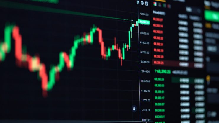 Ein Finanzhandelsdiagramm auf einem Bildschirm zeigt grüne und rote Kerzen mit Datenspalten auf der rechten Seite, die eine kürzliche Kurserholung im volatilen Krypto-Marktupdate hervorheben.