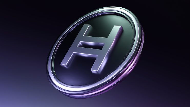 Eine Metallmünze mit dem Hedera Hashgraph-Logo, einem stilisierten H, neben dem ikonischen Dogecoin-Emblem auf einem dunklen Hintergrund mit Farbverlauf.