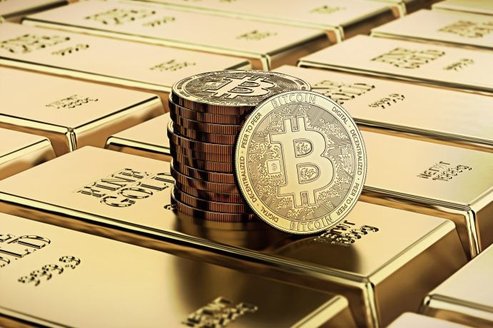 Ein Stapel Bitcoin-Münzen glänzt auf mehreren glänzenden Goldbarren.
