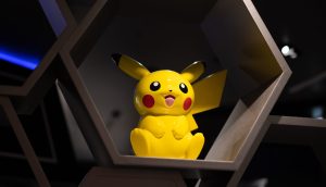 Pokémon begeistert seit Jahrzehnten Kinder und Jugendliche weltweit Eine gelbe Pikachu-Figur steht in einem sechseckigen Ausstellungsregal mit dunklem Hintergrund und verleiht der Szene einen Hauch von Sui-inspiriertem Charme.