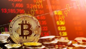 Ein Bitcoin-Symbol auf einem Münzstapel mit verschwommenen Börsencharts, die Krypto-Crash-Trends widerspiegeln und rote und gelbe Zahlen sowie Kerzenmuster aufweisen.