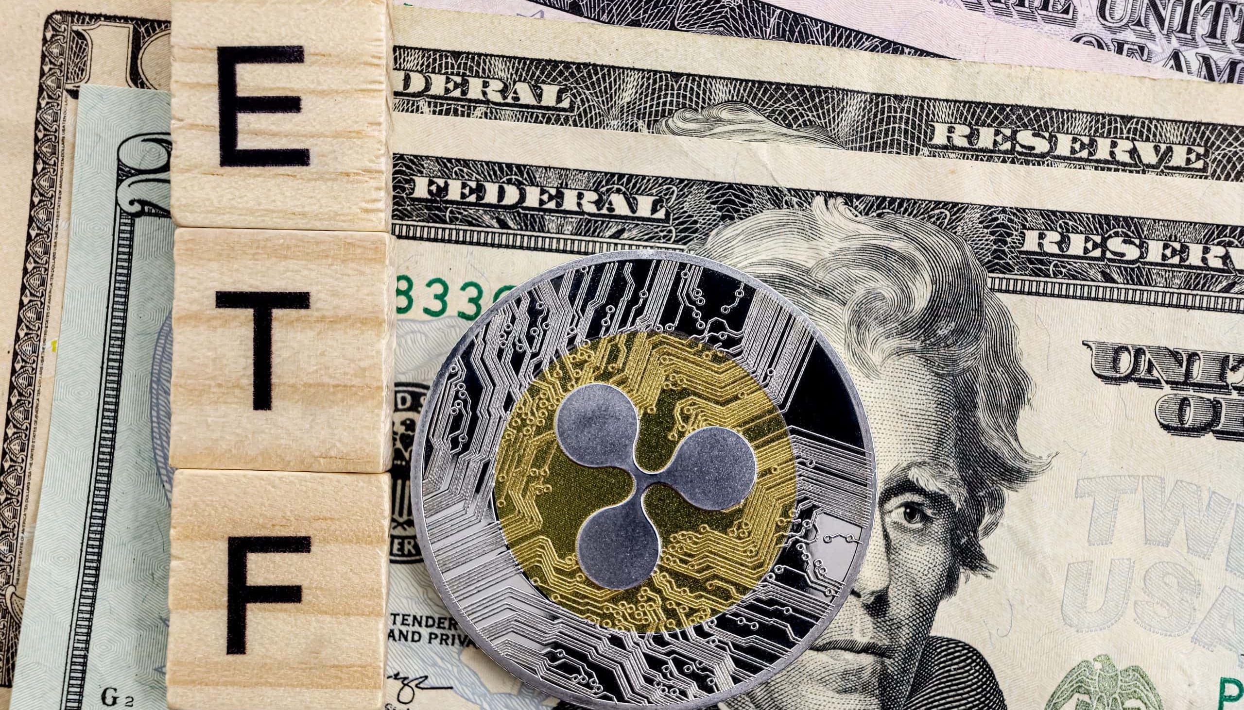 Eine Ripple-Kryptowährungsmünze liegt auf US-Dollarscheinen neben Holzfliesen mit dem Wort „ETF“, was auf das Potenzial für einen XRP-ETF in den USA hindeutet.