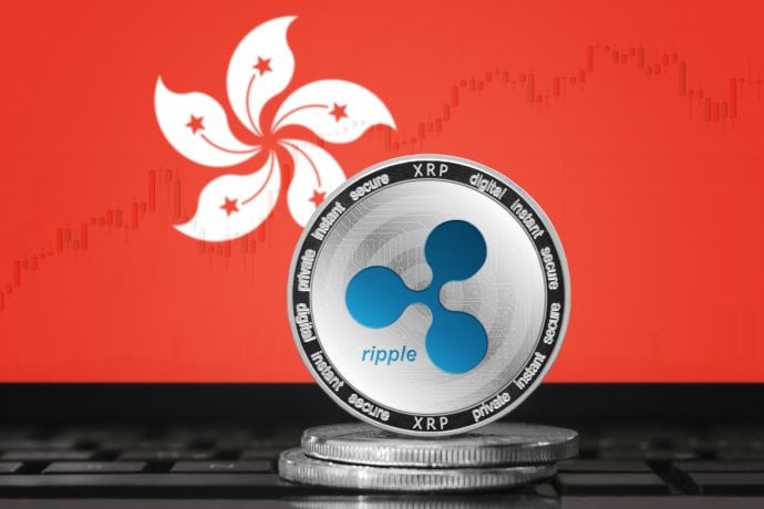 Eine Ripple-Münze (XRP) steht auf gestapelten Münzen vor einem Monitor, der die Flagge von Hongkong und ein schwaches Finanzdiagramm zeigt und den wachsenden Einfluss von Ripple Labs in Asien und das Interesse von XRP-Fonds symbolisiert.