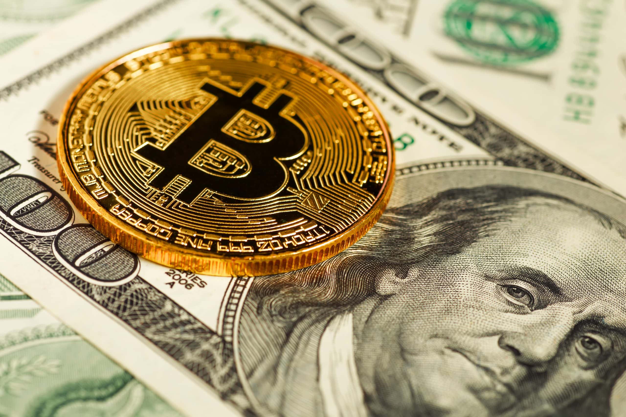 Eine glänzende physische Bitcoin-Münze liegt auf einem Stapel frischer 100-Dollar-Scheine und symbolisiert die Verschmelzung traditioneller und digitaler Währungen.
