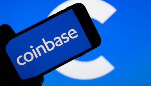 Eine Hand hält ein Smartphone mit dem Coinbase-Logo und einem großen, unscharfen Coinbase-C-Logo im Hintergrund, das die Bedeutung von Coinbase im digitalen Finanzwesen unterstreicht.
