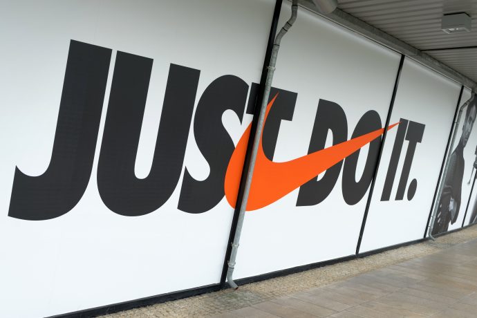Großes Wanddisplay mit dem Nike-Slogan „JUST DO IT“ mit dem orangefarbenen Nike-Swoosh anstelle des Buchstabens „O“.