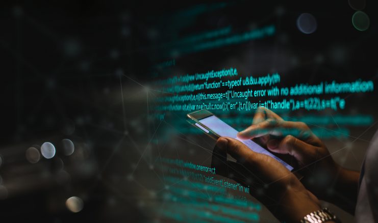Nahaufnahme von Händen, die in einer schattigen Umgebung ein Smartphone halten, mit grünem Code und Fehlermeldungen, die auf den Bildschirm projiziert werden – ein Einblick in die Welt der Krypto-Nutzer, die im Darknet navigieren.