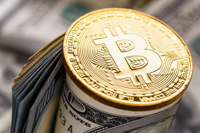 Eine goldene Bitcoin-Münze balanciert auf einem Bündel zusammengerollter US-Dollarscheine und symbolisiert die Interaktion zwischen Kryptowährung und herkömmlicher Währung. Zudem unterstreicht sie den reibungslosen Ablauf von Bitcoin-Transaktionen in der heutigen digitalen Wirtschaft.