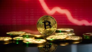 Bitcoin vor einem roten Hintergrund, Symbol für den BTC-Kursverlust
