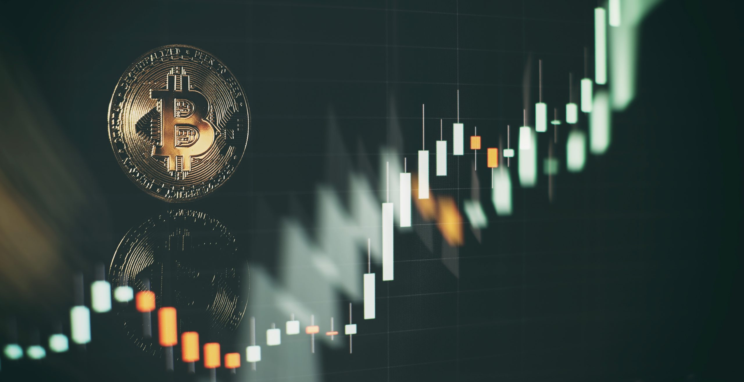 Eine Bitcoin-Münze steht vor einem unscharfen Hintergrund aus Krypto-Charts, wobei ein Candlestick-Chart eine aufwärts gerichtete und volatile Preisbewegung zeigt.