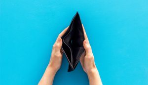 Zwei Hände halten vor einem leuchtend blauen Hintergrund eine leere schwarze Brieftasche offen und deuten damit die Suche nach Bitcoin an.