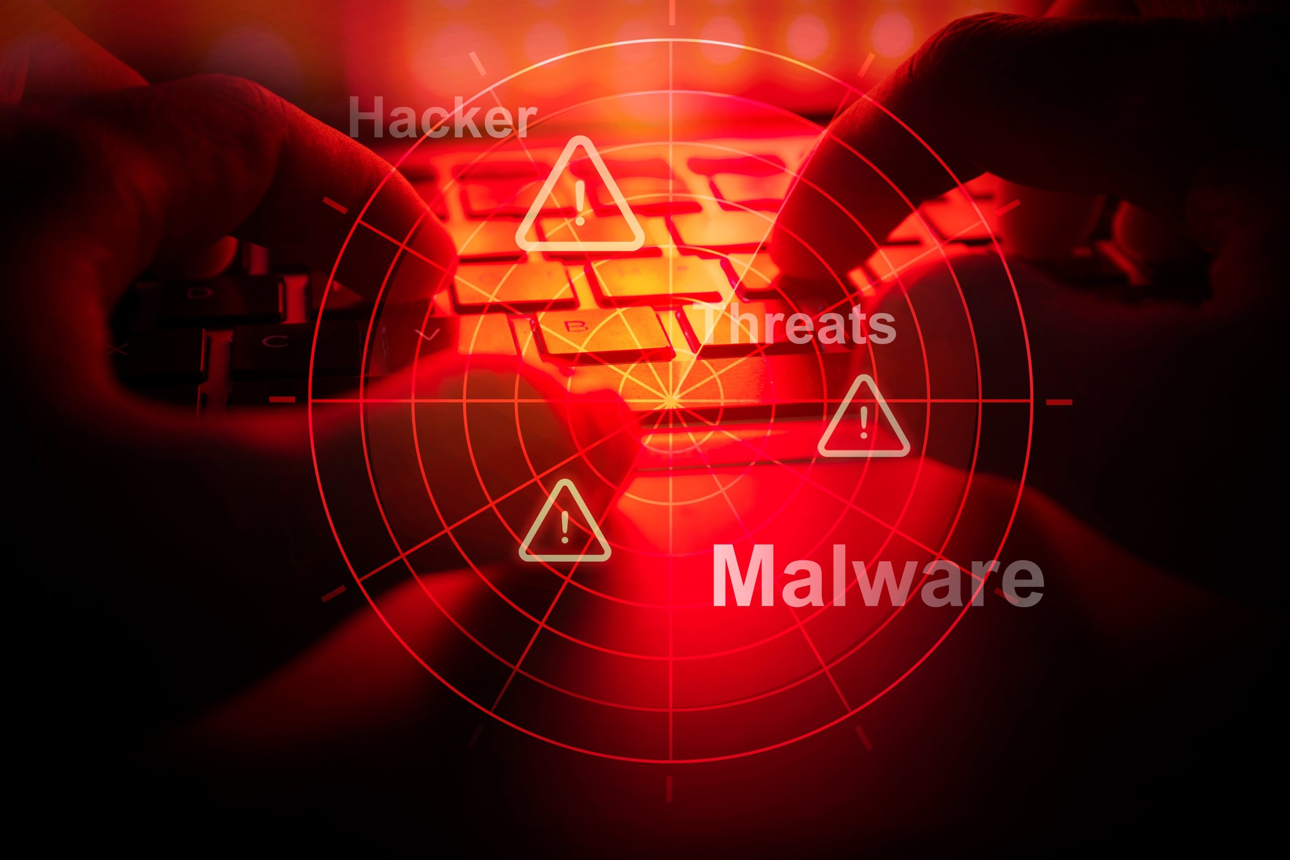 Hände tippen auf einer Tastatur mit roter Überlagerung, Radargrafiken und Wörtern wie „Hacker“, „Bedrohungen“, „Malware“ und „Krypto“, die auf Cybersicherheitsrisiken hinweisen.