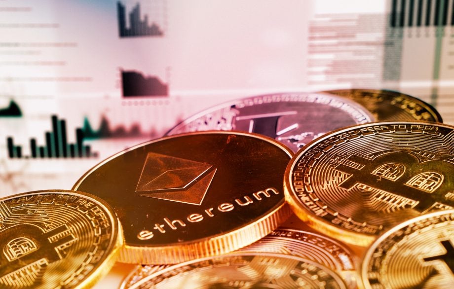Nahaufnahme von goldfarbenen Bitcoin- und Ethereum-Münzen mit unscharfen Finanzdiagrammen und -grafiken im Hintergrund, die den wachsenden Einfluss von Bitcoin im digitalen Finanzwesen hervorheben.