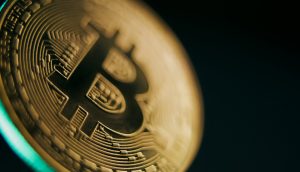 Nahaufnahme einer goldfarbenen physischen Bitcoin-Münze, die den Angebotsschock auf dem Markt symbolisiert, mit komplizierten Schaltkreisen und dem Bitcoin-Logo auf dunklem Hintergrund.