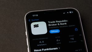 Die Trade Republic App wird auf dem Smartphone-Bildschirm angezeigt und zeigt Details wie eine 4,4-Sterne-Bewertung und die Eignung für Kinder ab 4 Jahren mit Schwerpunkt auf Investieren, Sparen und innovativen Krypto-Sparplänen.