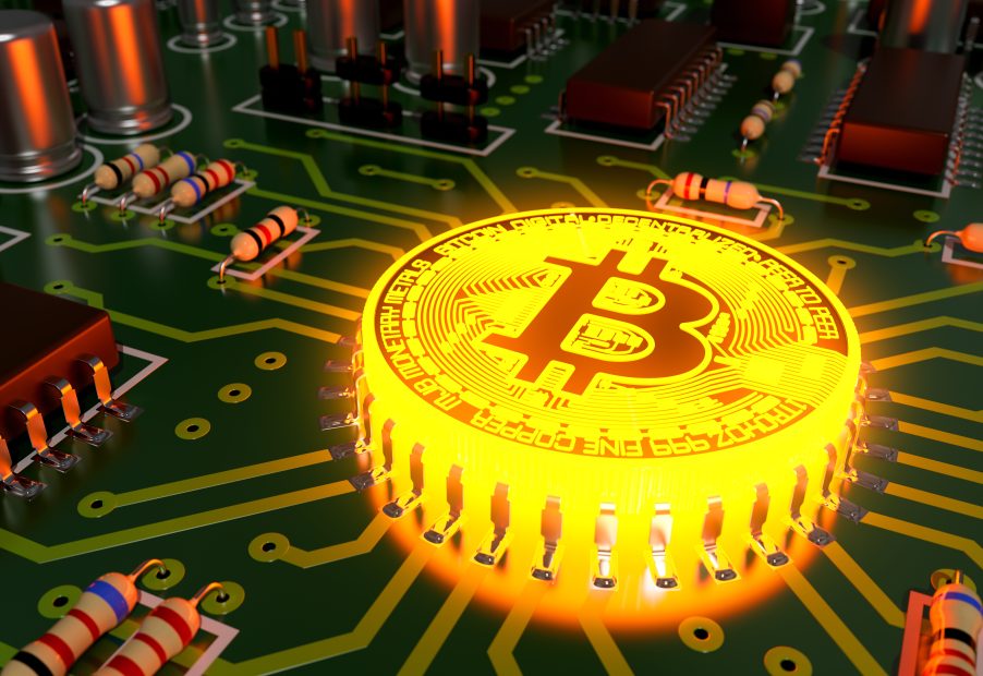 Ein leuchtendes Bitcoin-Symbol ist in eine Computerplatine integriert, umgeben von elektronischen Komponenten wie Widerständen, Transistoren und Hinweisen auf die Blockchain-Technologie.