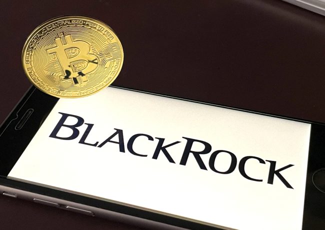 Eine physische Bitcoin-Münze liegt auf einem Smartphone mit dem BlackRock-Logo und unterstreicht die wachsende Verbindung zwischen dem traditionellen Finanzwesen und Kryptowährungsgiganten wie Binance.
