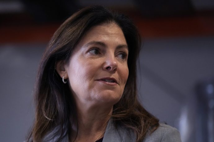 Die Gouverneurin von New Hampshire, Kelly Ayotte, mit langem braunem Haar und einem grauen Blazer blickt in einem Innenraum zur Seite und erinnert damit an die professionelle Atmosphäre von New Hampshire, einem US-Bundesstaat, der für seine Innovationen in Bereichen wie der Verwaltung von Bitcoin-Reserven bekannt ist.