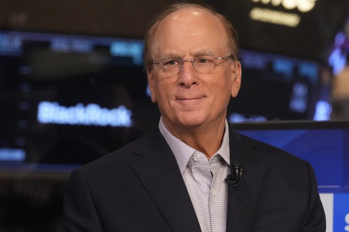 BlackRock CEO Larry Fink steht vor einem Hintergrund mit dem BlackRock-Logo und lächelt leicht – vielleicht denkt er über den jüngsten Rekordkurs von BlackRock mit seinem Bitcoin-ETF nach.