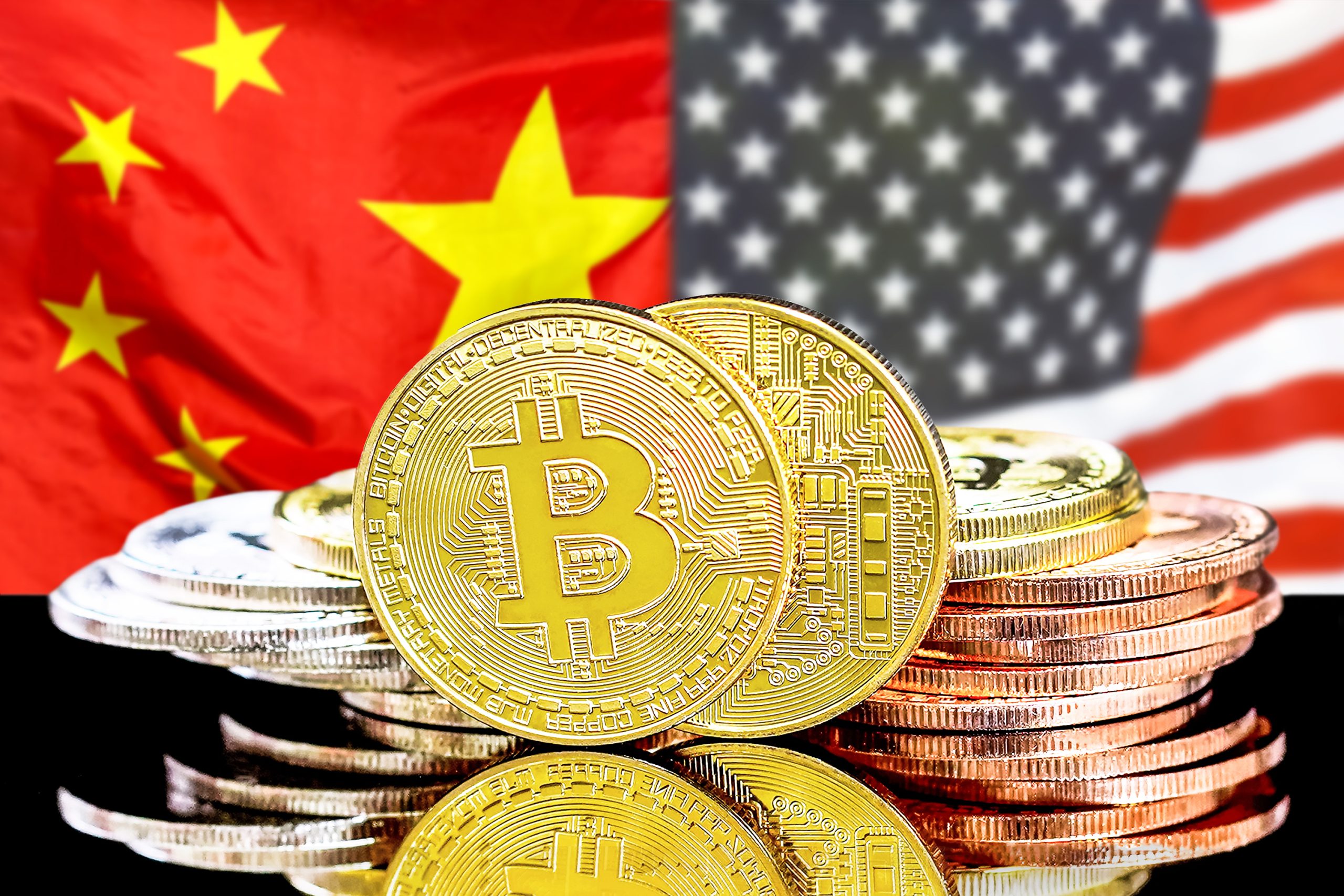 Bitcoin-Münzen vor einer USA- und China-Flagge