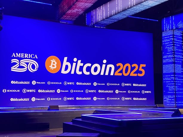 Eine Bühne mit einem großen Bildschirm, auf dem die Logos von America 250 und Bitcoin2025 angezeigt werden, umgeben von den Logos der entsprechenden Sponsoren und einer fesselnden digitalen Beleuchtung zum Thema Bitcoin.