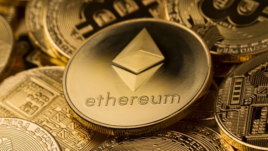 Nahaufnahme einer Ethereum-Münze, die auf mehreren anderen Kryptowährungsmünzen platziert ist, was die Präsenz von Ethereum auf dem Markt für digitale Währungen hervorhebt.