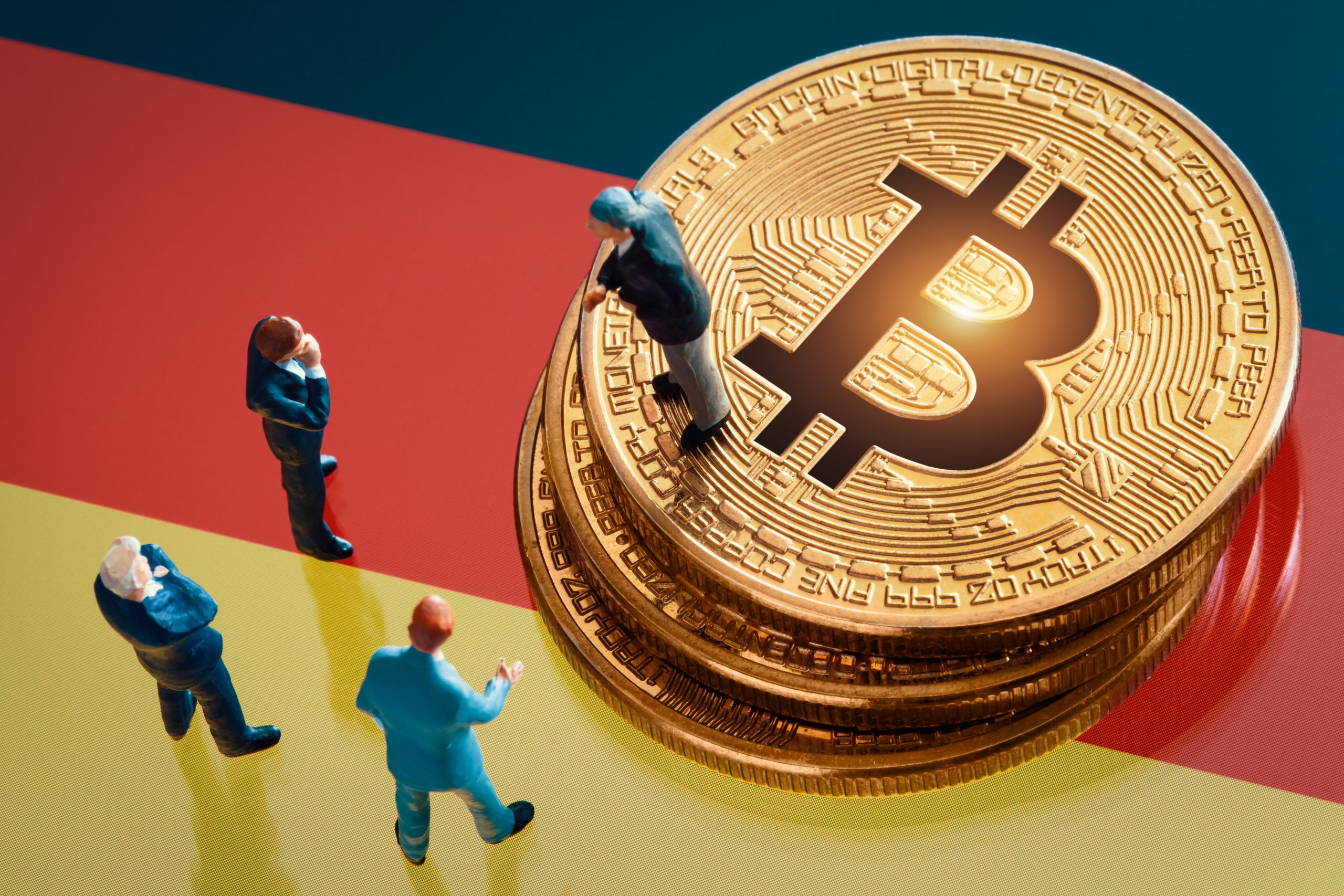 Eine Bitcoin-Münze liegt auf einer Deutschlandfahne