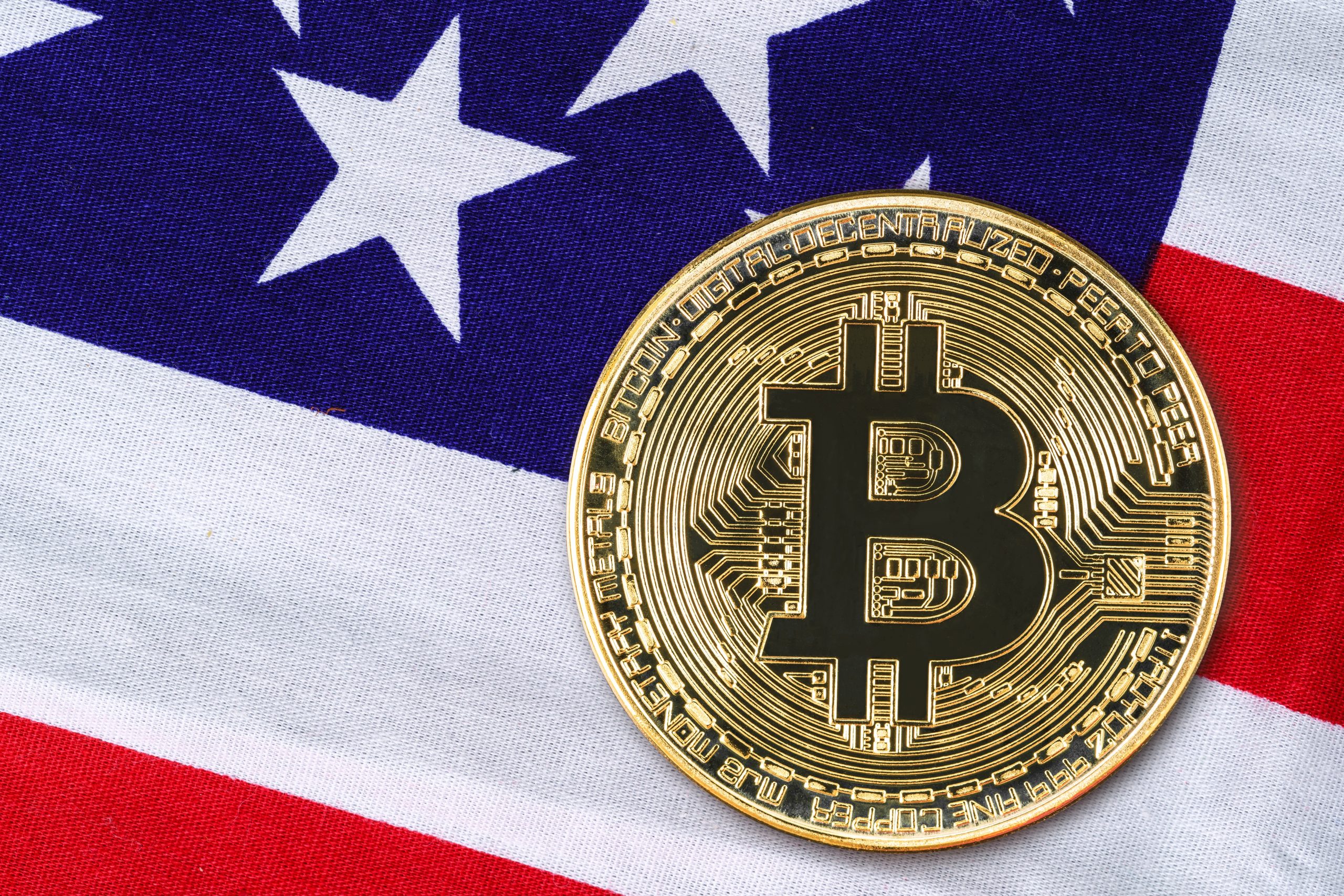 Eine Bitcoin-Münze vor einer US-Flagge