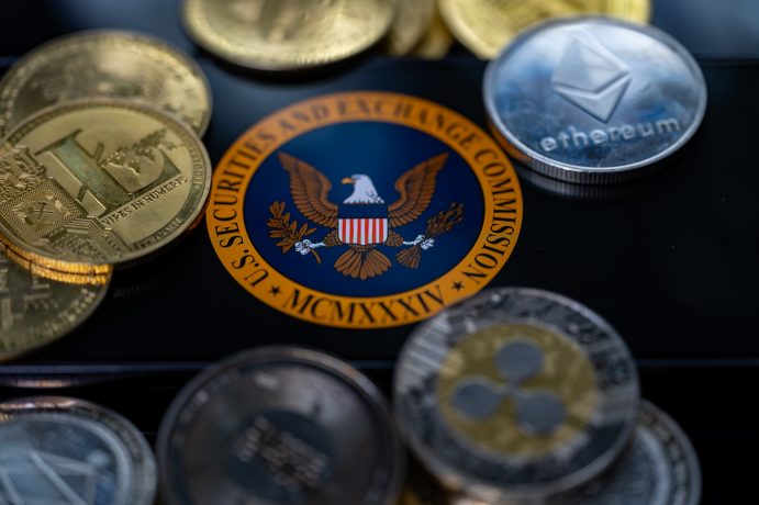 Eine Nahaufnahme verschiedener Kryptowährungen, darunter Bitcoin, Ethereum und Ripple, die das Siegel der US-Börsenaufsichtsbehörde SEC auf einer reflektierenden Oberfläche umgeben.