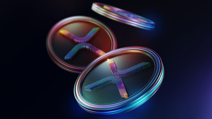 Drei glänzende, schillernde Münzen mit dem Logo der Kryptowährung Ripple (XRP) werden vor einem dunklen Hintergrund angezeigt und deuten auf die Vorfreude und Debatte um einen möglichen XRP-ETF nach seinem jüngsten Fehlstart hin.