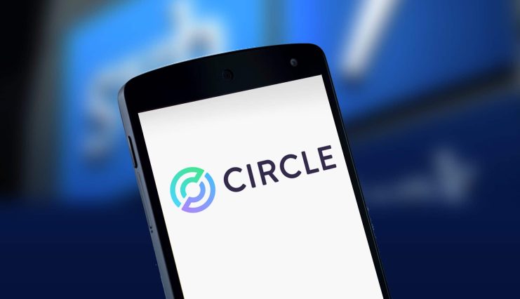 Auf dem Bildschirm eines Smartphones wird das Circle-Logo angezeigt, vor einem verschwommenen blauen Hintergrund mit undeutlichen Formen.