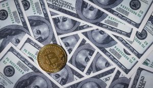 Eine goldene Bitcoin-Münze auf überlappenden 100-Dollar-Scheinen der USA verdeutlicht den wachsenden Einfluss von Bitcoin und Metaplanet in der Finanzlandschaft.