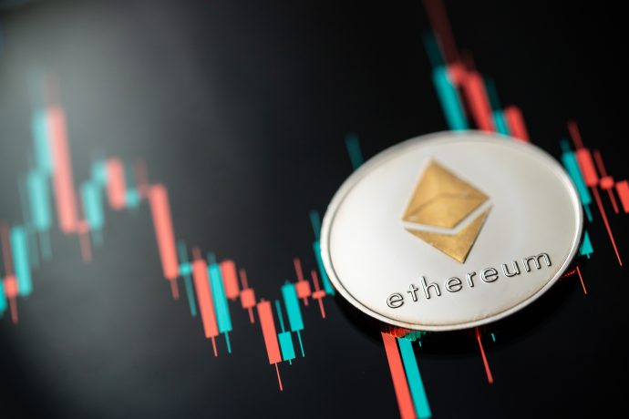Eine Ethereum-Münze liegt auf einem Candlestick-Chartdiagramm.