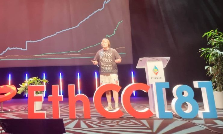 Aave-Gründer Stani Kulechov präsentiert eine Finanzdatengrafik mit dem Titel The Financial System is Getting Onchain auf der EthCC[8] und hebt dabei Aave hervor, mit roten Stühlen und Bühnenbeleuchtung im Hintergrund.