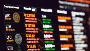 Ein digitaler Bildschirm zeigt US-Coins Kryptowährungspreise in USD für Bitcoin, Ethereum, Litecoin und Ethereum Classic an, zusammen mit prozentualen Veränderungen und Preistrends.