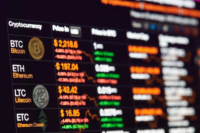 Ein digitaler Bildschirm zeigt US-Coins Kryptowährungspreise in USD für Bitcoin, Ethereum, Litecoin und Ethereum Classic an, zusammen mit prozentualen Veränderungen und Preistrends.