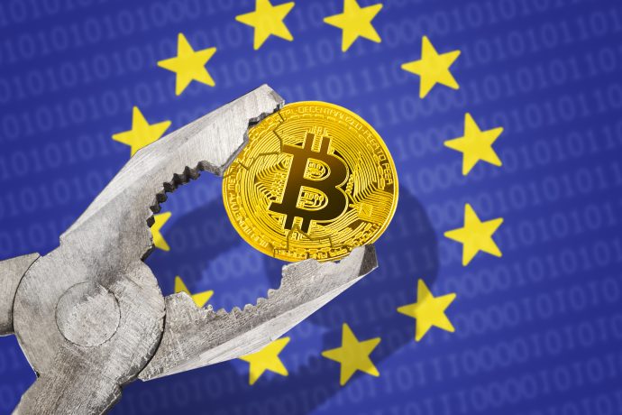 Eine Zange, die eine Bitcoin-Münze ergreift, vor der Flagge der Europäischen Union mit gelben Sternen auf blauem Grund, symbolisiert die regulatorischen Herausforderungen von Bitcoin in Europa.