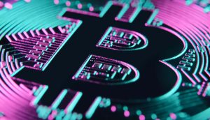 Nahaufnahme einer physischen Bitcoin-Münze, deren ikonisches Bitcoin-Symbol durch neonpinke und blaugrüne Lichteffekte beleuchtet wird.
