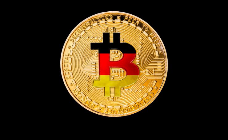 Eine goldene Bitcoin-Münze mit dem ikonischen Bitcoin-Symbol in den Farben der deutschen Flagge vor einem eleganten schwarzen Hintergrund.