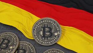 Ein Stapel Bitcoin-Token liegt vor einer deutschen Flagge und verdeutlicht den wachsenden Einfluss von Bitcoin in Deutschland.