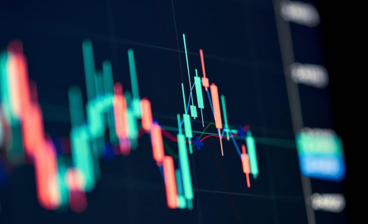 Eine Nahaufnahme eines digitalen Finanzcharts mit Candlestick-Mustern in Rot und Grün auf dunklem Hintergrund, der die XRP-Trends inmitten volatiler US-Zahlen auf dem Krypto-Markt verfolgt.
