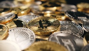 Bitcoin und verschiedene Kryptowährungsmünzen sind auf dem Bild dicht nebeneinander gestapelt und verstreut.