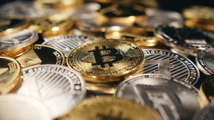 Bitcoin und verschiedene Kryptowährungsmünzen sind auf dem Bild dicht nebeneinander gestapelt und verstreut.