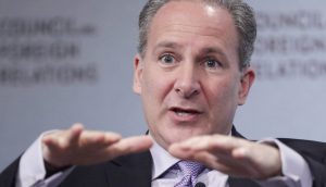 Peter Schiff, im Anzug, gestikuliert mit beiden Händen, während er auf einer öffentlichen Veranstaltung spricht, ein Mikrofon an seiner Krawatte befestigt und ein verschwommener Hintergrund hinter ihm.