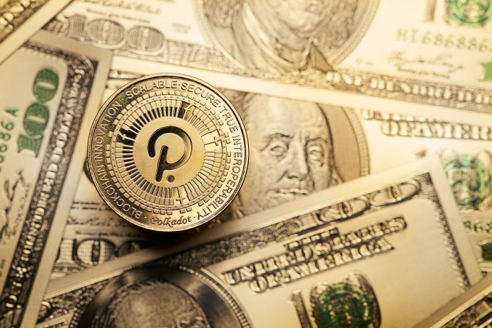 Eine Polkadot-Kryptowährungsmünze sitzt auf verstreuten US-Hundert-Dollar-Scheinen und unterstreicht die wachsende Präsenz von Polkadot in der Welt der digitalen und traditionellen Finanzen.