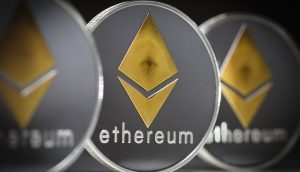 Nahaufnahme von drei physischen Münzen mit dem Ethereum-Logo und dem Wort "Ethereum" in Kleinbuchstaben, die die Präsenz von Ethereum in der Welt der Kryptowährungen unterstreichen.