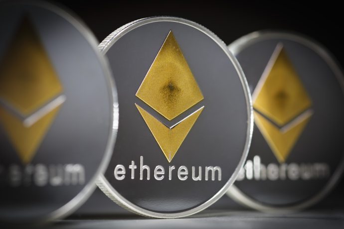 Nahaufnahme von drei physischen Münzen mit dem Ethereum-Logo und dem Wort "Ethereum" in Kleinbuchstaben, die die Präsenz von Ethereum in der Welt der Kryptowährungen unterstreichen.