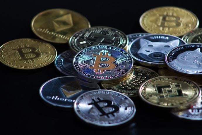 Auf einer dunklen Oberfläche wird ein Stapel verschiedener physischer Kryptowährungsmünzen angezeigt, darunter Bitcoin, Ethereum, Litecoin und andere – ein automatisch gespeicherter Entwurf der digitalen Währungswelt in greifbarer Form.